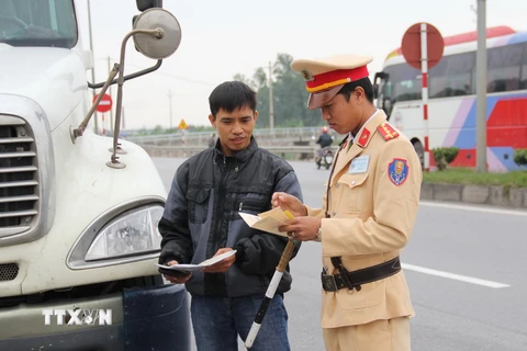 Cảnh sát giao thông trạm Tân Đệ kiểm tra các phương tiện trên tuyến QL10, đoạn qua địa bàn huyện Vũ Thư. (Ảnh: Xuân Tiến/TTXVN)