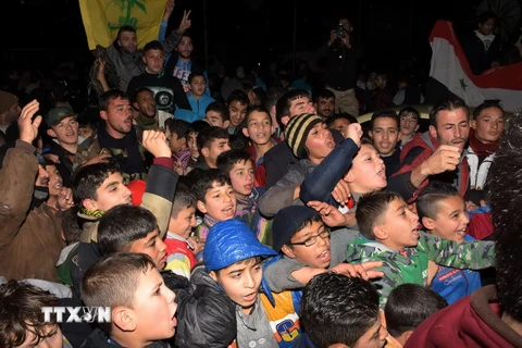 Người dân Syria vui mừng sau khi quận Mogambo của thành phố Aleppo được giải phóng ngày 12/12. (Nguồn: AFP/TTXVN)
