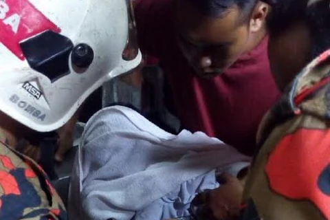 Độicứu hộ EMRS đang dùng khoan để rút tay cậu bé ra khỏi máy cạo dừa (Nguồn: nst.com.my)