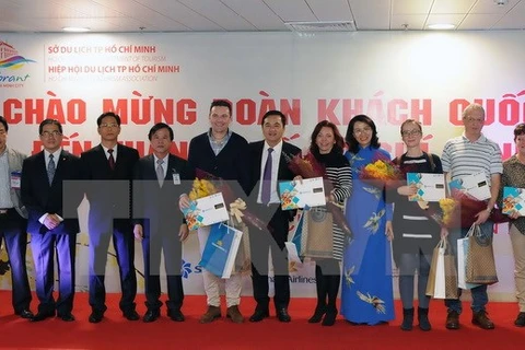 Đại diện lãnh đạo Thành phố Hồ Chí Minh với đoàn khách du lịch quốc tế đầu tiên trong năm 2017. (Ảnh: An HiếuTTXVN)