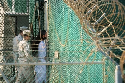 Binh sỹ Mỹ chuyển một tù nhân tại nhà tù Vịnh Guantanamo. (Nguồn: AFP/TTXVN)