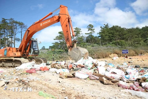 Tiêu huỷ hơn 10 tấn mứt Tết không rõ nguồn gốc tại bãi rác Cam Ly chiều 23/1. (Ảnh: Nguyễn Dũng/TTXVN)