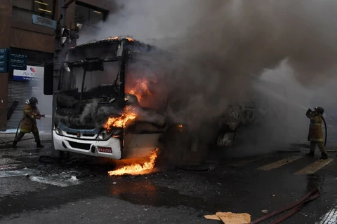 Chiếc xe buýt bị người biểu tình đốt. (Nguồn: AFP)
