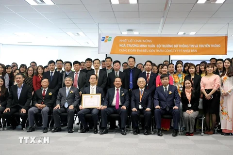 Bộ trưởng Bộ Thông tin và Truyền thông Trương Minh Tuấn trao bằng khen và chụp ảnh lưu niệm với lãnh đạo, nhân viên FPT Nhật Bản. (Ảnh: Thành Hữu/Vietnam+)