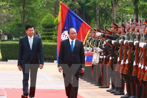 Thủ tướng Nguyễn Xuân Phúc và Thủ tướng Lào Thongloun Sisoulith duyệt Đội danh dự. (Ảnh: Thống Nhất/TTXVN)