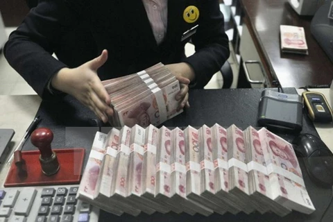 Kiểm đồng nhân dân tệ tại một ngân hàng ở Trung Quốc. (Ảnh: Reuter/TTXVN)