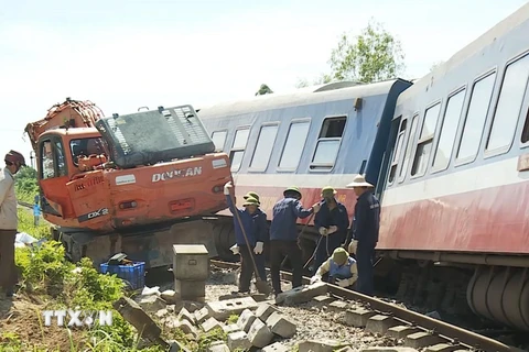 Lực lượng chức năng đang nỗ lực khắc phục hậu quả vụ tai nạn đường sắt ở Quảng Bình. (Ảnh: Võ Dung/TTXVN)