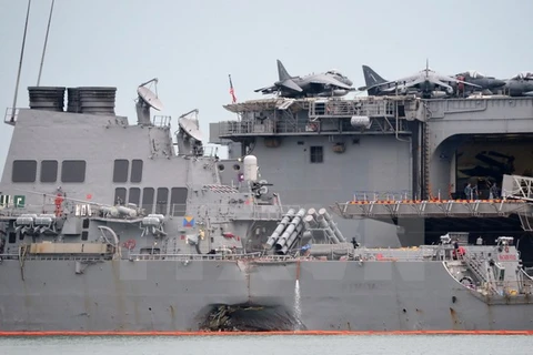 Một bên thân Tàu USS John S. McCain bị hư hỏng sau vụ va chạm với tàu chở dầu ở vùng biển ngoài khơi Singapore được lai dắt về căn cứ hải quân Changi ở Singapore ngày 22/8. (Nguồn: AFP/TTXVN)