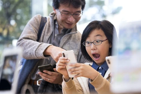 Khuôn mặt rạng rỡ của một khách hàng ở Tokyo, Nhật Bản khi trên tay iPhone X. (Nguồn: Getty)