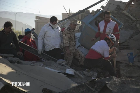 Lực lượng cứu hộ tìm kiếm người sống sót trong động đất ở tỉnh Kermanshah, Iran ngày 13/11. (Nguồn: AFP/TTXVN)