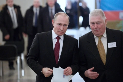  Đương kim Tổng thống Nga Vladimir Putin (trái) bỏ phiếu tại điểm bầu cử ở Moskva ngày 18/3. (Nguồn: THX/TTXVN)