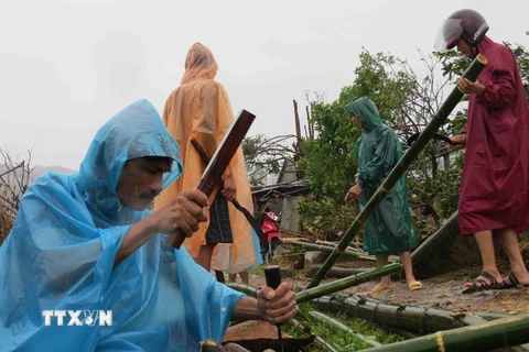 Người dân tỉnh Quảng Bình khắc phục hậu quả sau một trận lốc xoáy và lũ. (Ảnh: TTXVN)