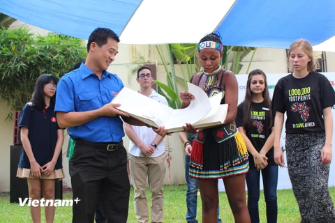 Đại sứ tê giác Nam Phi trao cuốn sách bảo vệ tê giác cho đại diện Đoàn Thanh niên Cộng sản Hồ Chí Minh. (Ảnh: Hùng Võ/Vietnam+)