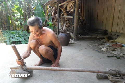 Ông Mông Văn Sau đang trau chuốt đồ nghề hoạn trâu, bò. (Ảnh: PV/Vietnam+)