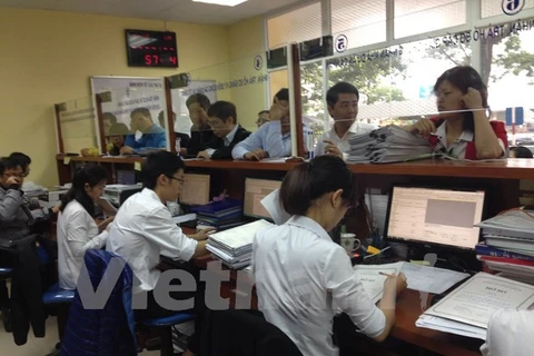 Người dân đi làm thủ tục cấp sổ đỏ tại Văn phòng đăng ký đất đai. (Ảnh: H.T/Vietnam+)