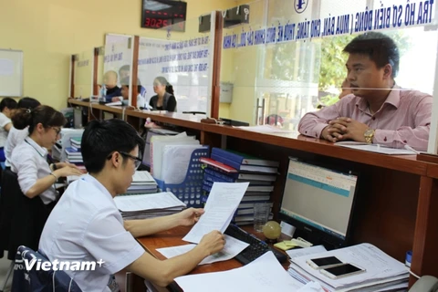 Cán bộ Văn phòng Đăng ký đất đai Hà Nội tiếp nhận thủ tục tại bộ phận một cửa. (Ảnh: PV/Vietnam+)