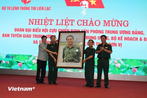 Đại diện Hội Cựu chiến binh 5 cơ quan Trung ương trao tặng phẩm cho Bộ tư lệnh Thông tin liên lạc. (Ảnh: Hùng Võ/Vietnam+)