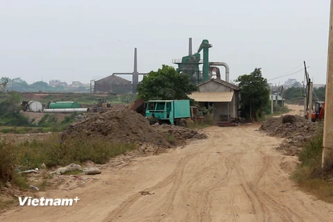 Bùn thải chất từng đống ở trên triền đê sông Hồng, thuộc địa bàn xã Đại Mạch, huyện Đông Anh. (Ảnh: MM/Vietnam+)