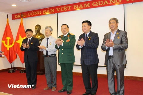 Thượng tướng Nguyễn Văn Được (chính giữa) trao kỷ niệm chương cho các đồng chí cán bộ, hội viên Hội Cựu chiến binh TTXVN. (Ảnh: PV/Vietnam+)