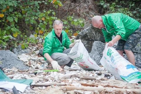 Đại sứ Hoa Kỳ tại Việt Nam Ted Osius và tình nguyện viên thu gom rác trên Vịnh Hạ Long. (Ảnh: IUCN Việt Nam)