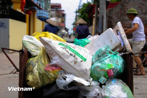 Việc thu gom rác tại các ngõ xóm dưới 2m tại các huyện ngoại thành Hà Nội đang gặp rất nhiều khó khăn. (Ảnh: Q.Sỹ/Vietnam+)