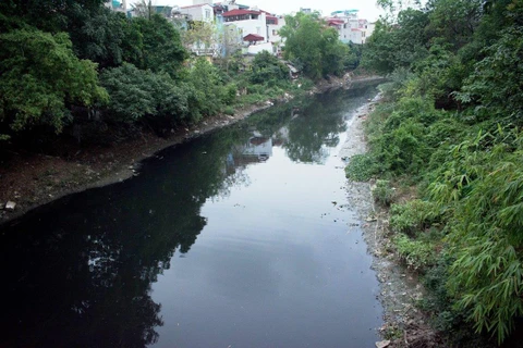 Nước sông Nhuệ đen như mực. (Ảnh: P.V/Vietnam+)