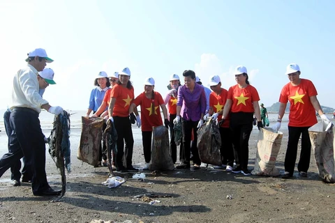 Thứ trưởng Võ Tuấn Nhân (ngoài cùng bên trái) và các đại biểu với cán bộ hội viên phụ nữ tại địa phương thu gom rác thải dọc bờ biển Đồ Sơn. (Ảnh: An Đăng/TTXVN