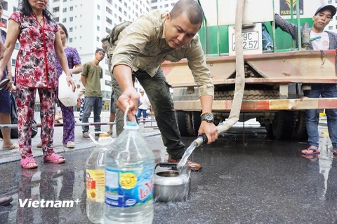 Người dân Hà Nội phải mua, hoặc nhận nước sạch để sử dụng. (Ảnh: PV/Vietnam+)