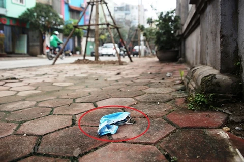 Khẩu trang y tế đã qua sử dụng bị vứt bỏ, nhếch nhác trên vỉa hè, đường phố Hà Nội. (Ảnh: PV/Vietnam+)