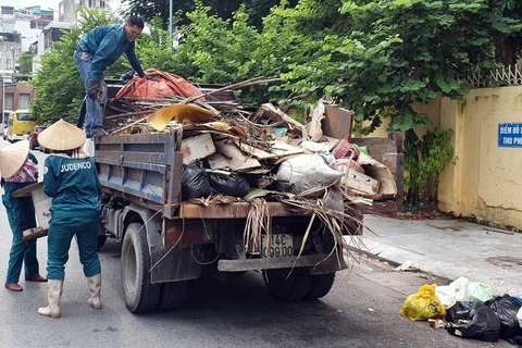 Công nhân vệ sinh môi trường thu gom rác thải ở thành phố Hạ Long và Cẩm Phả. (Nguồn ảnh: TTXVN phát)