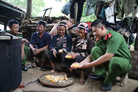 Cán bộ công an xã Huổi Luông, huyện Phong Thổ, tỉnh Lai Châu trò chuyện với người dân trên địa bàn. (Ảnh: Hùng Võ/Vietnam+)