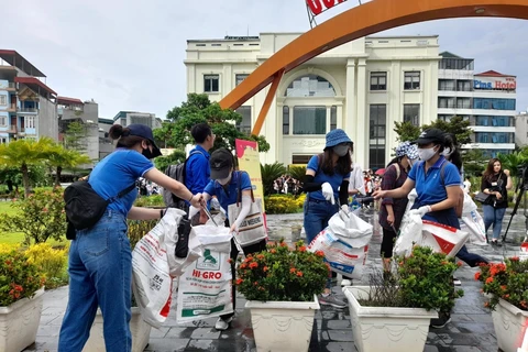 Các tình nguyên viên chia thành nhóm thu gom rác thải trên đường phố Hà Nội. (Ảnh: Hùng Võ/Vietnam+)