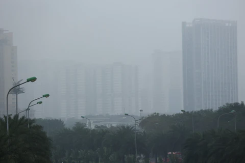 Sương màu dày đặc bao phủ khắp Hà Nội khiến nhiều nhà cao tầng "chìm" trong bầu không khí mờ ảo. (Ảnh: Hoài Nam/Vietnam+)