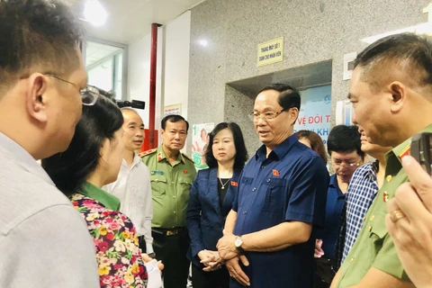 Phó Chủ tịch Quốc hội Trần Quang Phương (đeo kính) trao đổi về tình hình vụ cháy và thăm hỏi sức khỏe các nạn nhân đang điều trị tại Bệnh viện Giao thông Vận tải vào sáng 24/5. (Ảnh: Tuyết Mai/TTXVN)