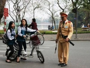 Cảnh sát giao thông xử lý học sinh đi xe đạp điện vi phạm Luật giao thông. (Ảnh: Việt Hùng/Vietnam+)