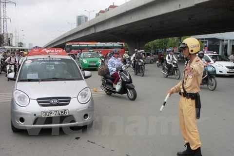 Cảnh sát giao thông xử phạt xe taxi vi phạm Luật giao thông. (Ảnh: Việt Hùng/Vietnam+)