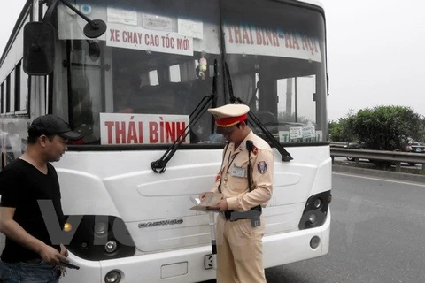 Cảnh sát giao thông kiểm tra xe khách vi phạm. (Ảnh: Việt Hùng/Vietnam+)
