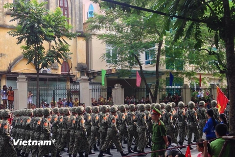 Người dân náo nức khi đoàn diễu binh, diễu hành đi qua tuyến đường. (Ảnh: Nhóm PV/Vietnam+)