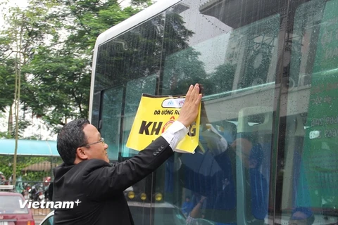 Dán khẩu hiệu "Đã uống rượu, bia không lái xe" trên xe buýt. (Ảnh: Việt Hùng/Vietnam+)