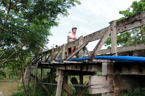 Người dân lưu thông trên cầu gỗ Ba Ngạn tại xã Khánh Hoà, huyện Châu Phú, Anh Giang. (Ảnh: Tân Hiệp Phát cung cấp)