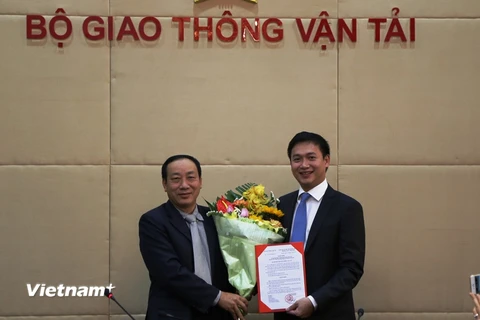 Thứ trưởng Nguyễn Hồng Trường trao hoa và quyết định bổ nhiệm cho ông Nguyễn Xuân Ảnh. (Ảnh: Minh Phương/Vietnam+) 