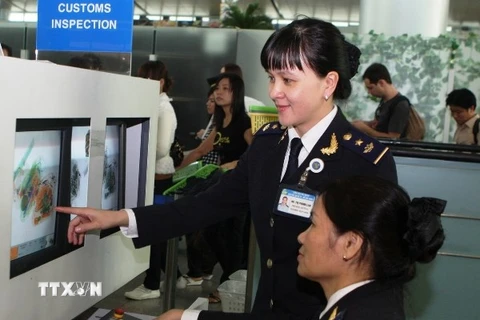 Nhân viên soi chiếu hàng không kiểm tra an ninh tại sân bay Nội Bài. (Ảnh: TTXVN)