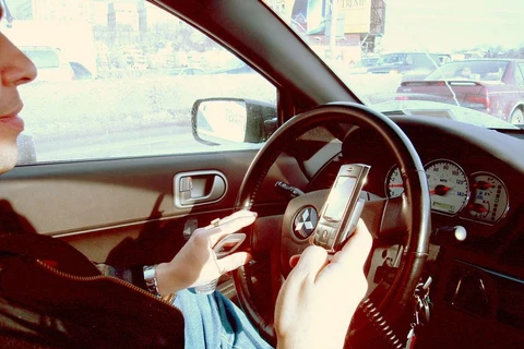 Khi lái ôtô, sử dụng điện thoại để nghe gọi hoặc nhắn tin sẽ làm người điều khiển mất tập trung, qua đó làm giảm khả năng xử lý tình huống. (Ảnh: news.go.vn)