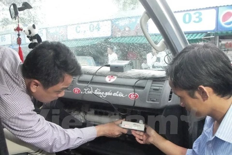 Kiểm tra thiết bị hộp đen được lắp đặt trên xe khách. (Ảnh: Việt Hùng/Vietnam+)