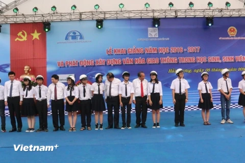 Phó Thủ tướng trao mũ bảo hiểm cho học sinh trường Trung học phổ thông chuyên Nguyễn Trãi. (Ảnh: Việt Hùng/Vietnam+) 