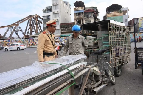 Cảnh sát giao thông Đội 1, Công an Hà Nội kiểm tra, xử lý xe chở hàng cồng kềnh. (Ảnh: Doãn Tấn/TTXVN)