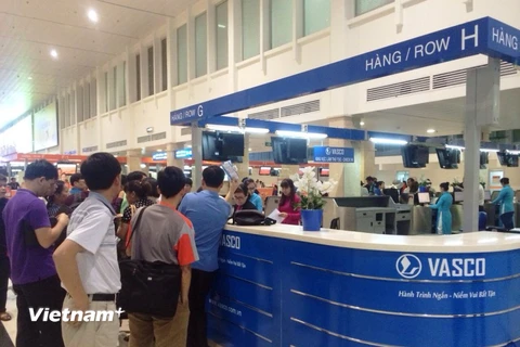 Rất đông hành khách bị hủy chuyến bay tập trung trước quầy làm thủ tục để nhận được lời giải thích từ VASCO. (Ảnh: Phạm Anh Tuấn/Vietnam+)