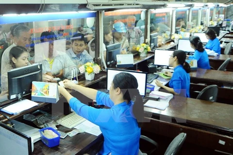 Nhân viên bán vé tàu cho hành khách tại Ga Hà Nội. (Ảnh: Quang Quyết/TTXVN)
