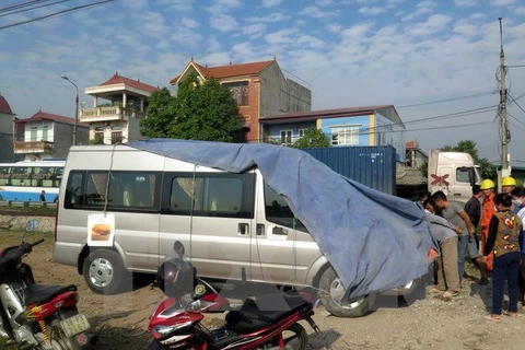 Hiện trường vụ tai nạn giao thông giữa xe chở khách bị tàu hỏa đâm tại Nam Định. (Ảnh: Văn Đạt/TTXVN)