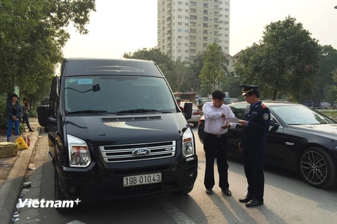 Thanh tra giao thông vận tải Hà Nội kiểm tra xe Limousine chạy quanh cổng sau khu vực Big C. (Ảnh: Đức Hùng/Vietnam+)